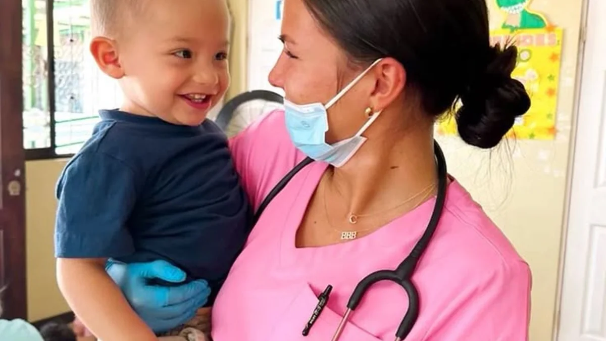 Paediatric nurse carrying a small child on a childrens ward