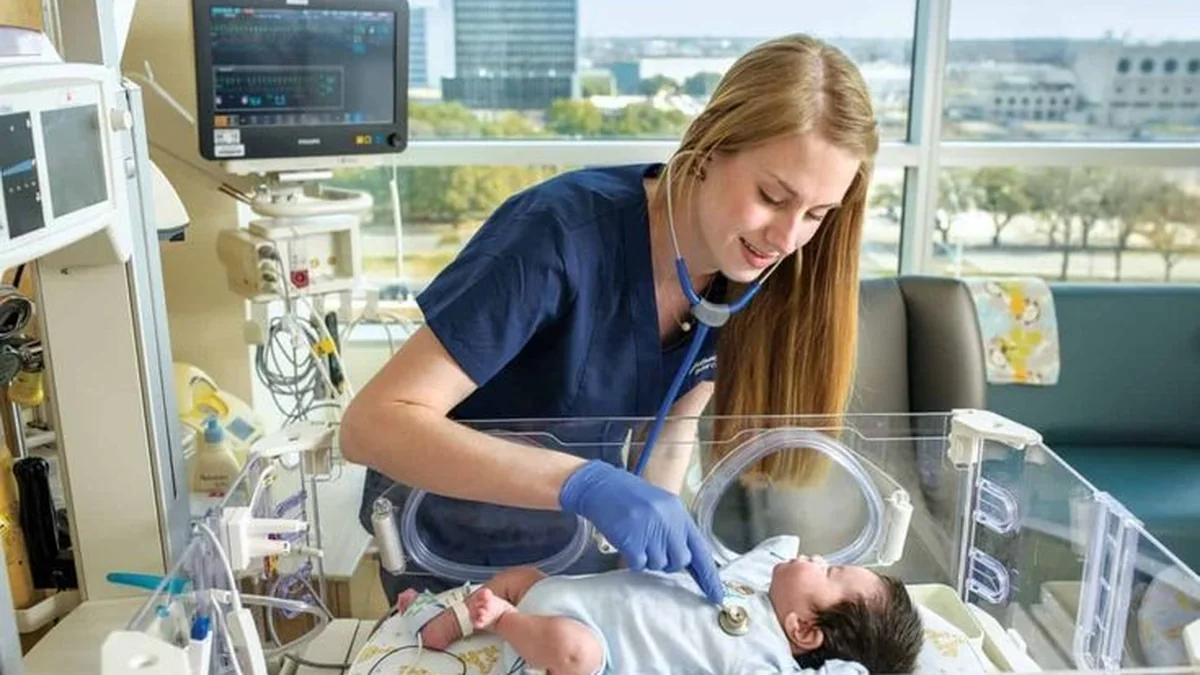 Neonatal nurse examining a newborn in an incubator